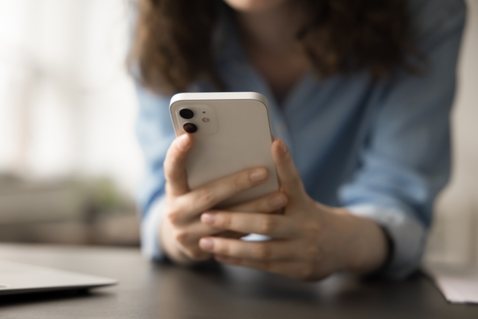 Feature image Person holding mobile phone, close up of hands and phone.